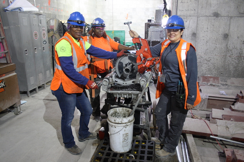 Journeywomen Nuelin Thompson, Tamara Lamond (Forewoman) and Rosalinda Nevarez of Five Star Electric pose in front of a conduit bender on the job at the MTA's East Side Access Project.